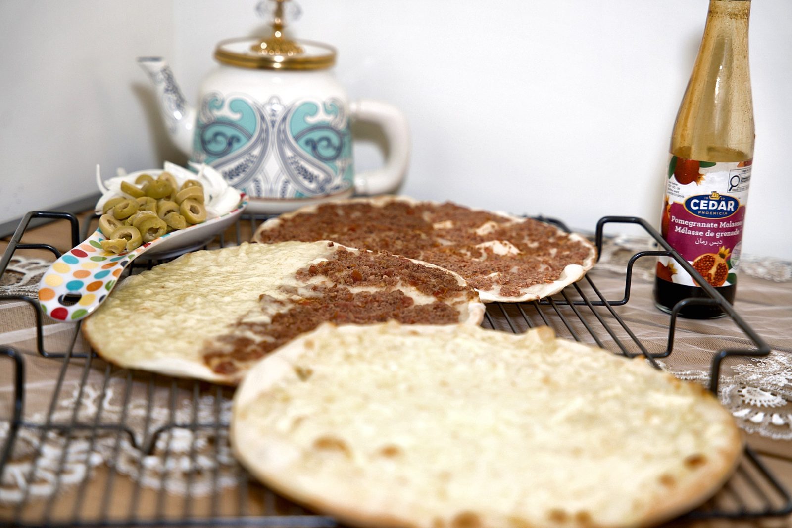 Lebanese spread of cheese and meat manakish with olives, tea and pomegranate molasses