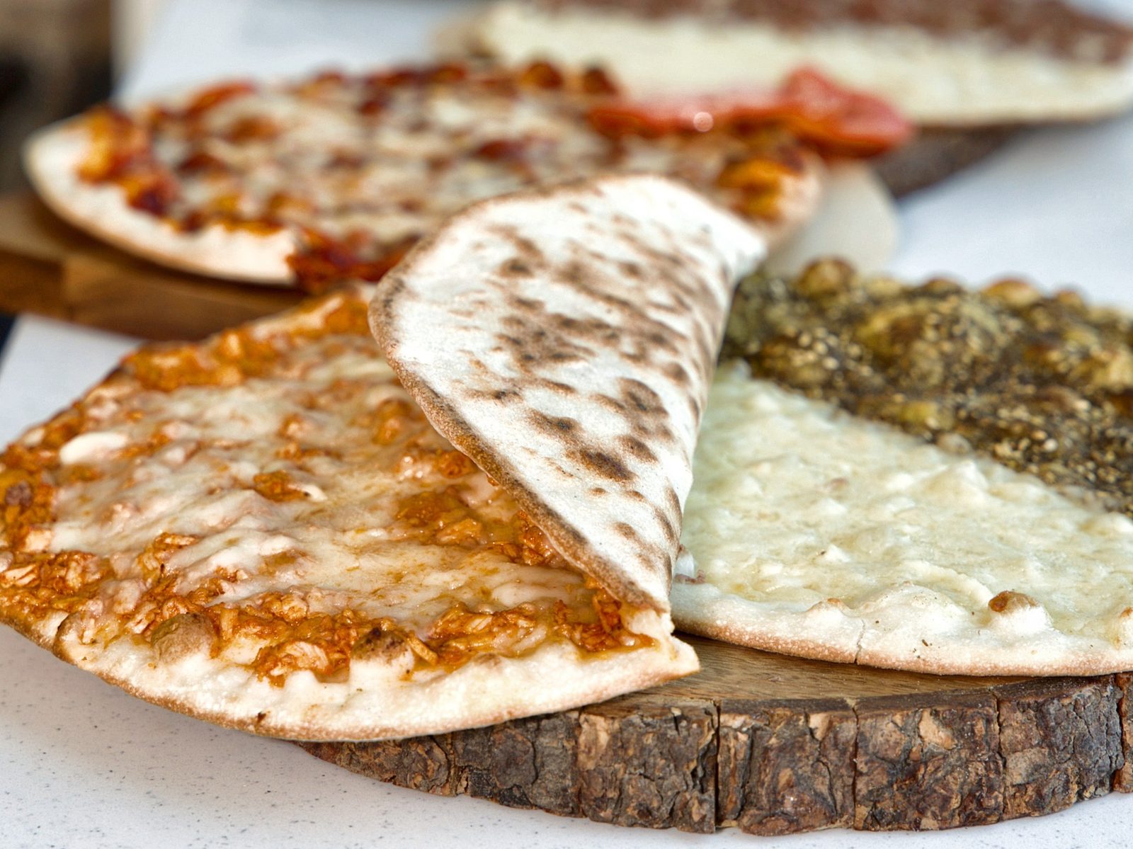 Freshly baked cheese, zaatar and meat manakish served on a wooden board